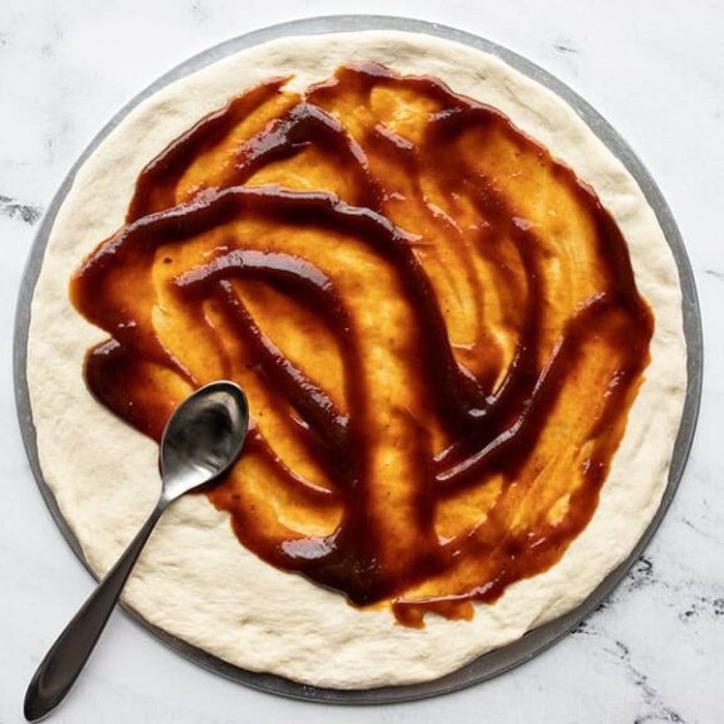 Ajoutez de la sauce barbecue a la pate a pizza