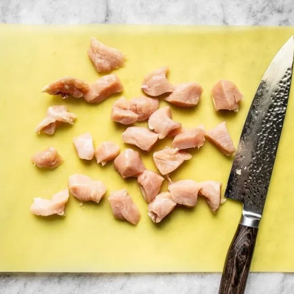 poitrine de poulet coupée en petits cubes pour préparer les nuggets maison au four