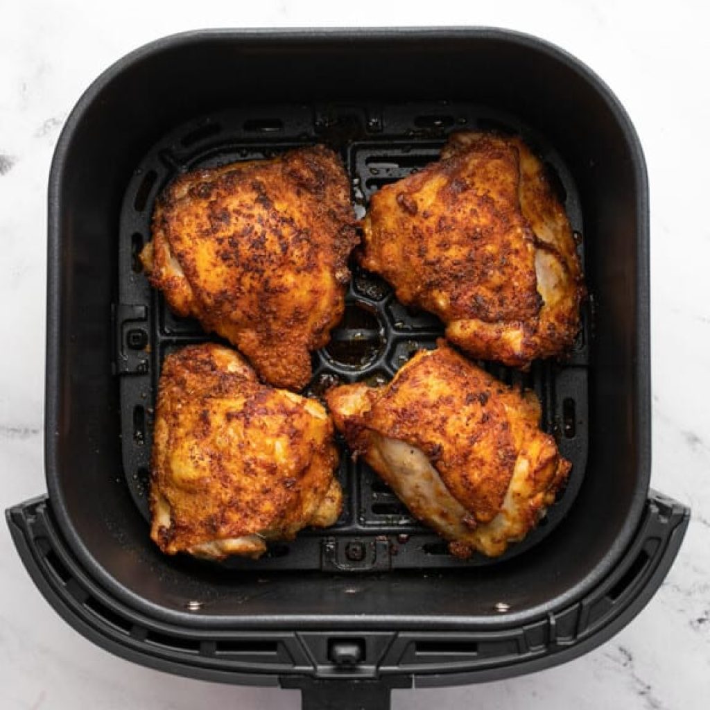 hauts de cuisse de poulet croustillants et dorés prêts dans le panier de l'air fryer