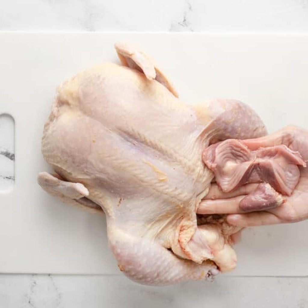 Poulet cru retiré de son emballage, prêt à être placé sur une grille au centre du four préchauffé à 425 °F.
