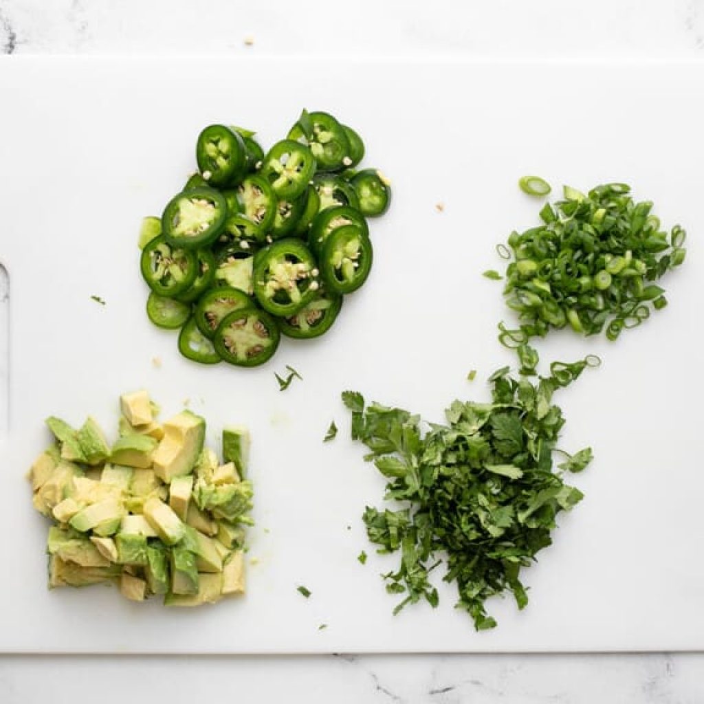 garnitures fraîches préparées pour nachos au poulet : avocat, jalapeño, coriandre et oignons verts