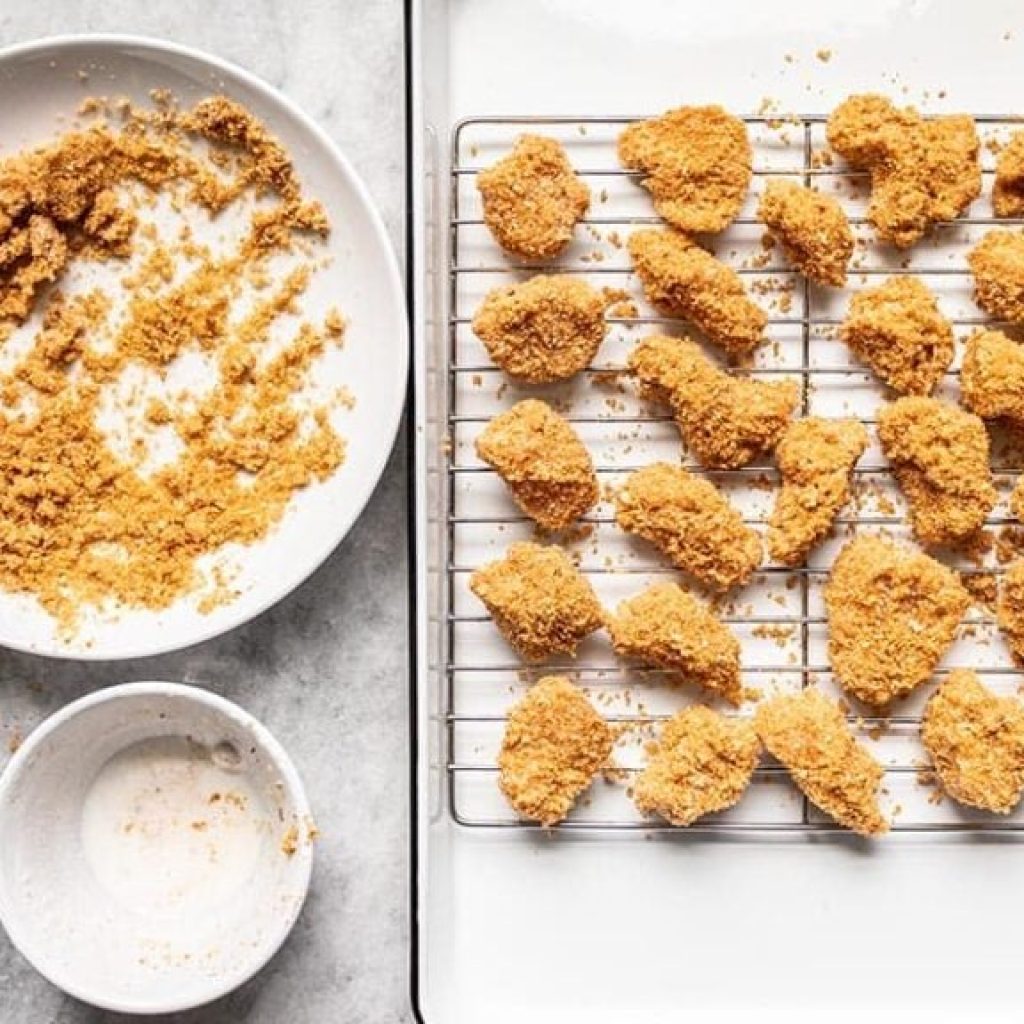 nuggets de poulet maison panés et disposés sur grille prêts à cuire au four à 220°C