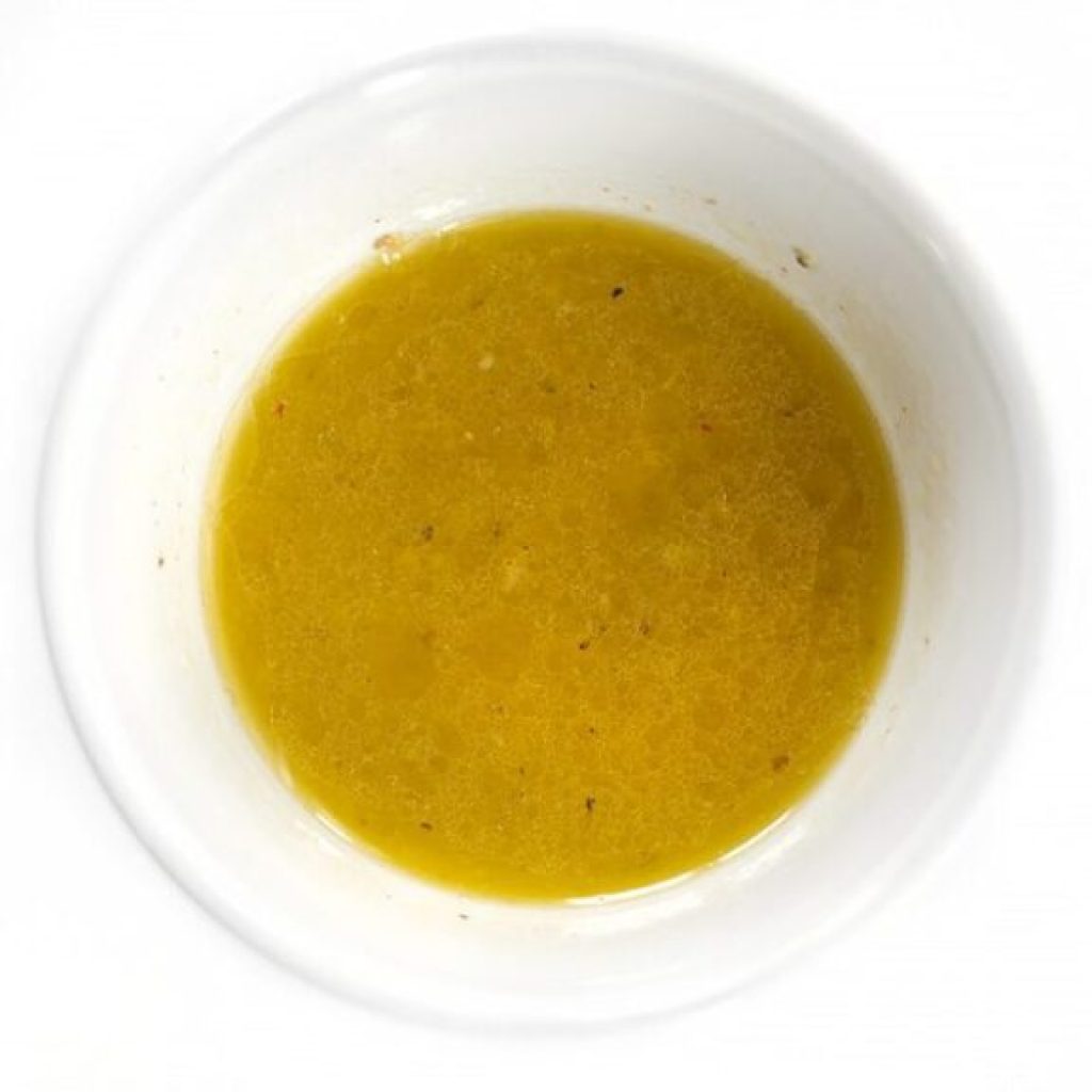 marinade citron ail pour blanc de poulet basse température : huile d'olive, jus de citron et ail émincé fouettés dans un bol