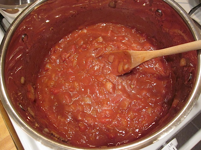 Sauce tomate mijotant dans une casserole, préparation pour poulet au beurre mijoteuse