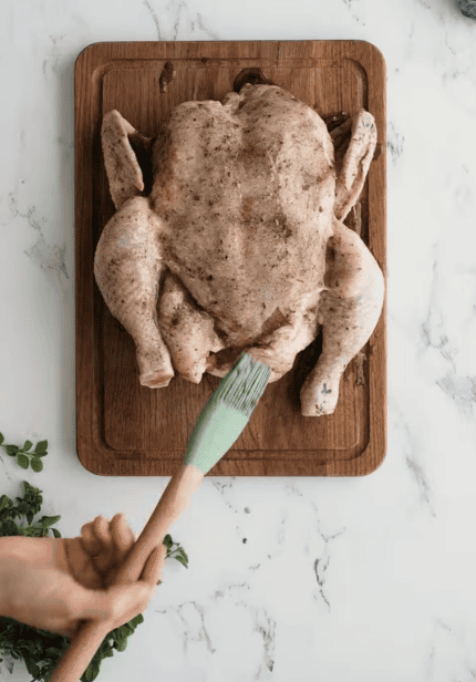 poulet entier badigeonné d'huile d'olive et d'épices avant cuisson à l'air fryer