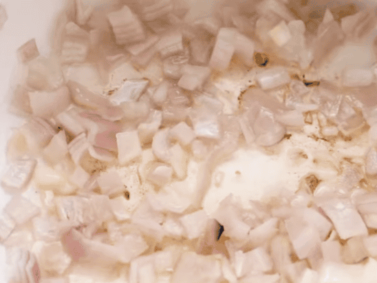 échalotes hachées revenues dans l'huile pour la base du curry massaman au poulet