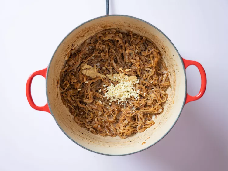 Les parfums d'oignons caramélisés et d'ail fondent dans la cocotte, annonçant un délicieux plat à venir.