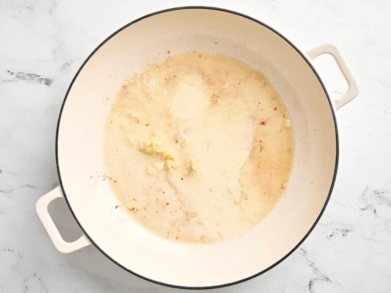 beurre et ail émincé fondant dans la poêle pour la sauce crémeuse des boulettes de poulet