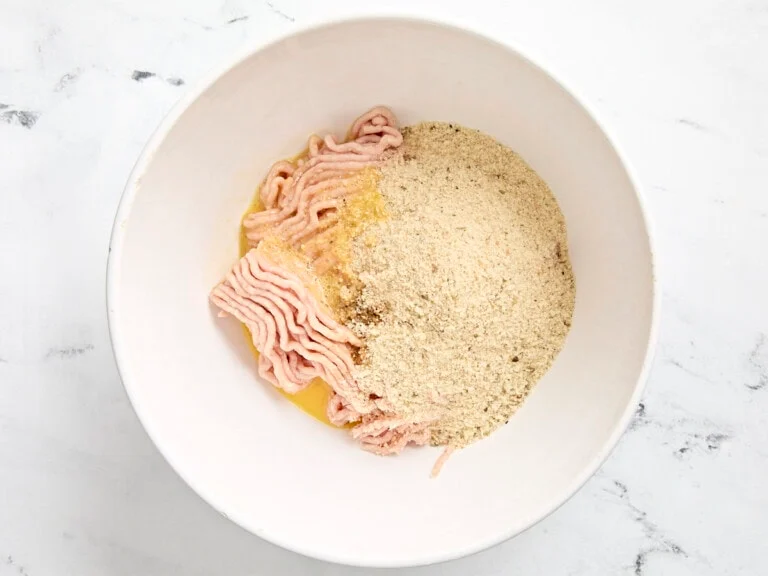 farce poulet haché œuf et chapelure mélangés dans un bol prête à former des boulettes