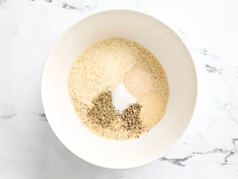 mélange chapelure, parmesan, épices dans un bol pour préparer les boulettes de poulet haché