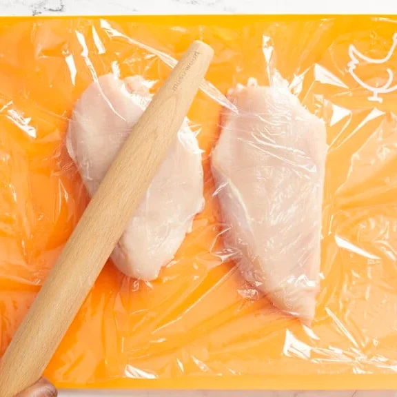 aplatir la poitrine de poulet avec un rouleau à pâtisserie pour une épaisseur uniforme avant cuisson air fryer