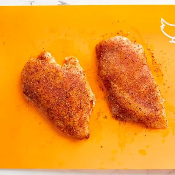 poitrine de poulet badigeonnée d'huile d'olive et enrobée d'épices avant cuisson à l'air fryer