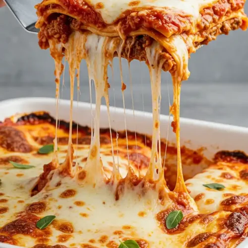 Lasagnes au poulet avec du fromage fondant étirant, servies dans un plat blanc.